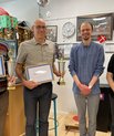 Image of four men - two holding certificates