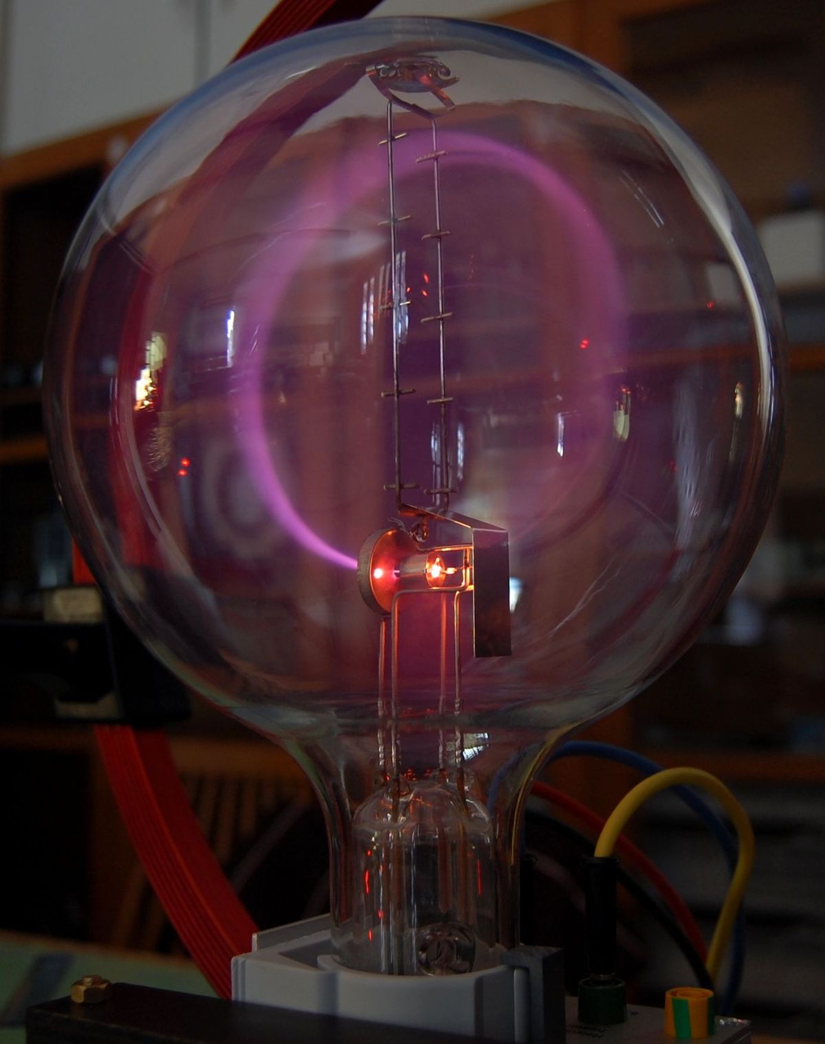 Strømme er normalt ikke synlige, men kan gøres synlige ved fluoresens. På billedet ses en katode stråle som afbøjes i en magnetisk felt skabt af en Helmholtz spole.