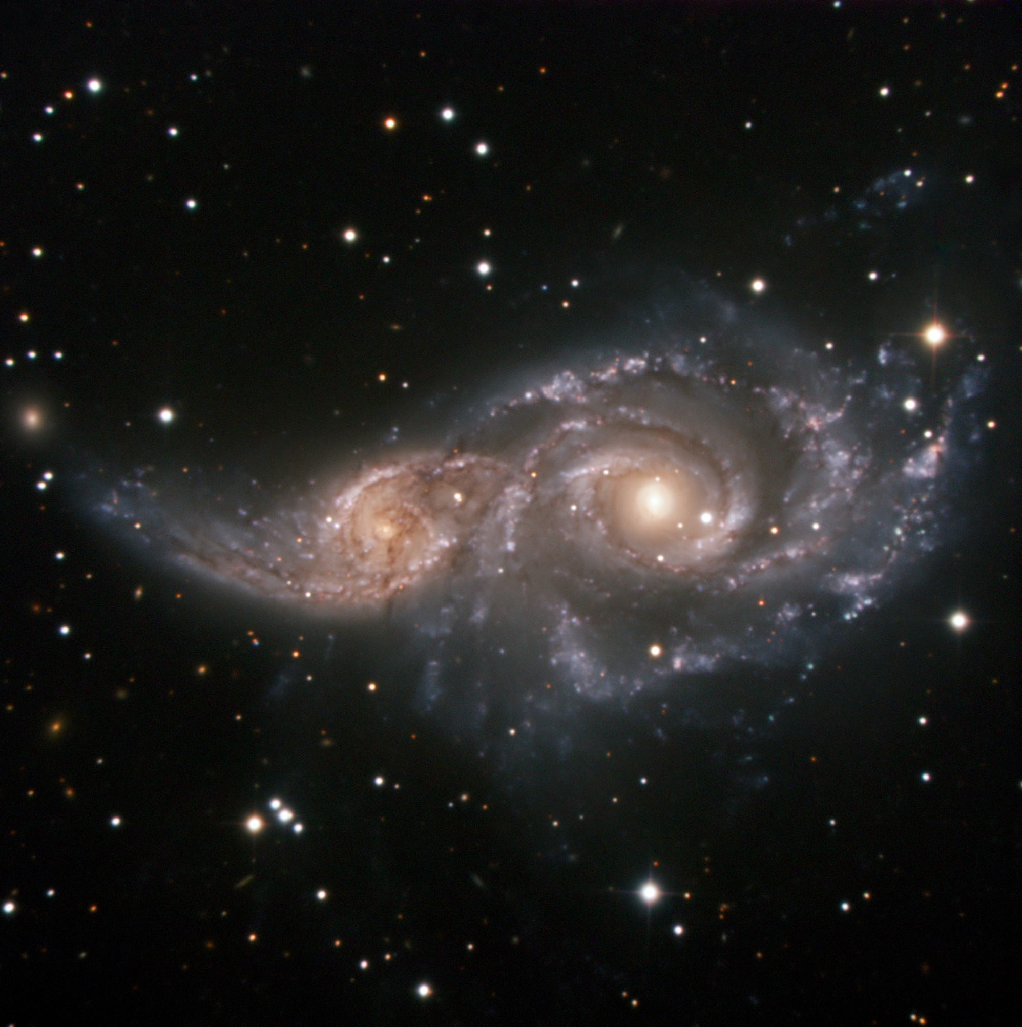 To galakser, som begge ligner Mælkevejen, danser en kosmisk ballet, som i løbet af et par milliarder år vil ende med, at de smelter sammen til en større galakse. Disse her, med katalognumrene NGC 2207 og IC 2163,  befinder sig i stjernebilledet Store Hund