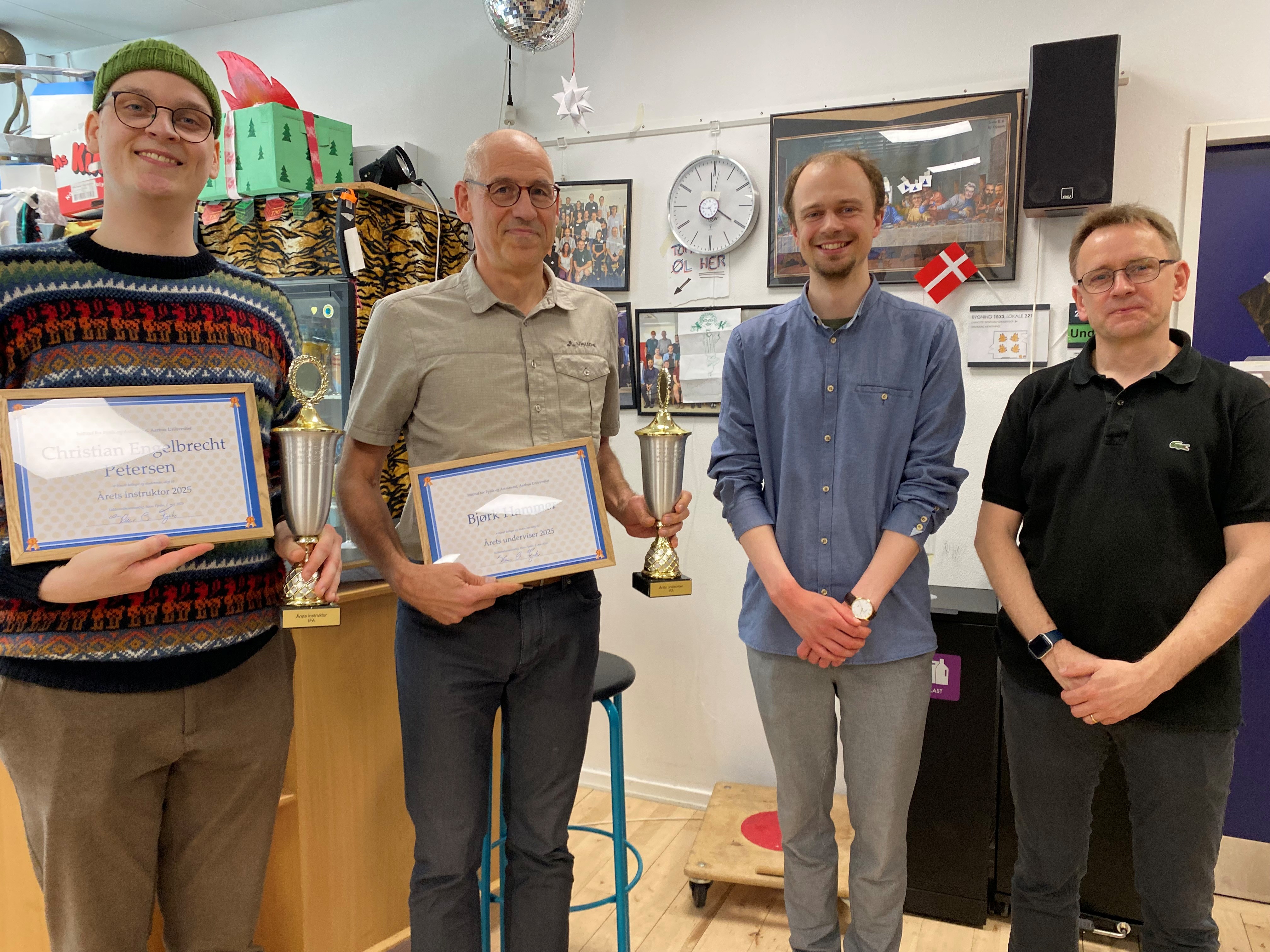Image of four men - two holding certificates